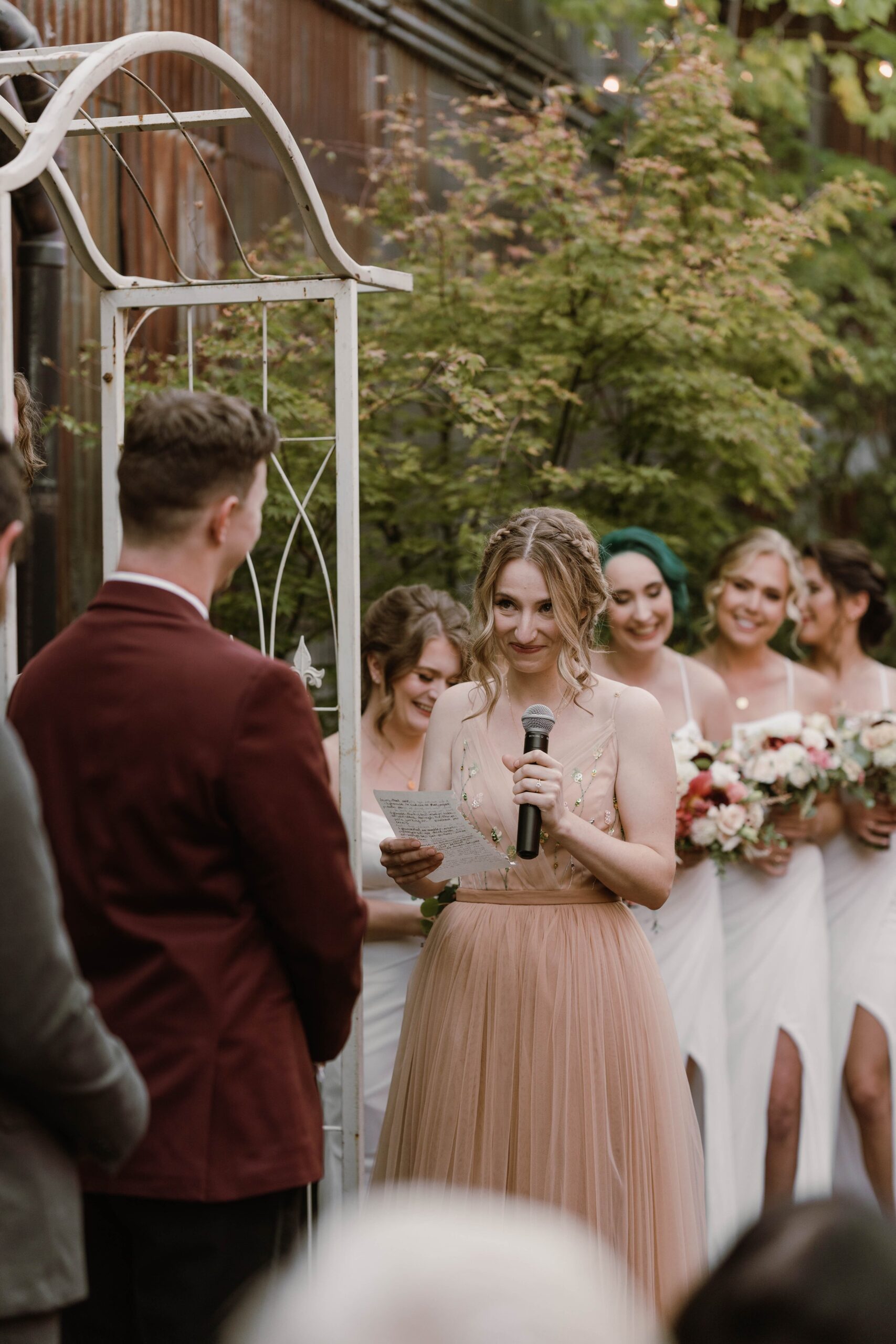 bride in pink dress reads personal vows