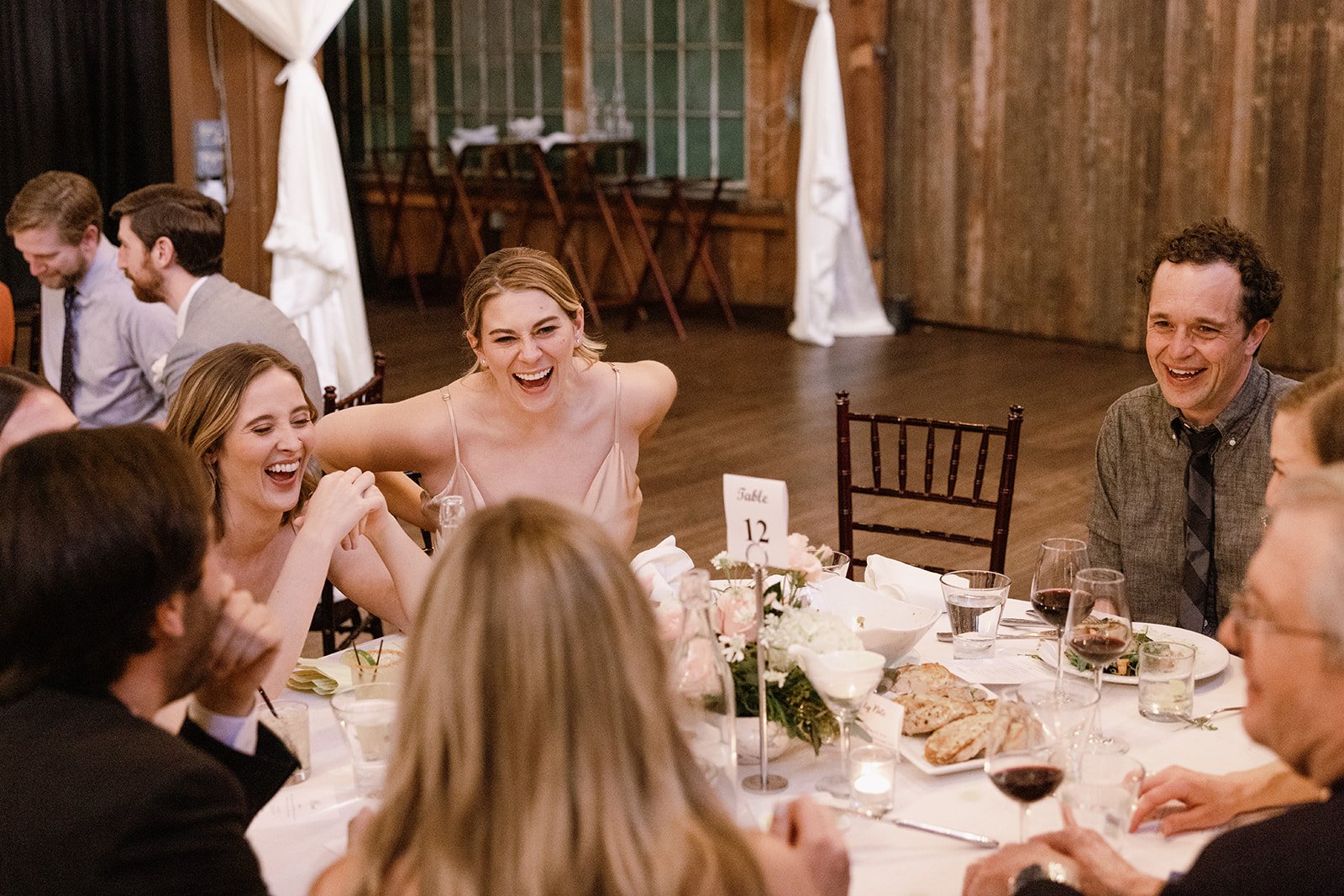wedding guests laughs at table mates during reception