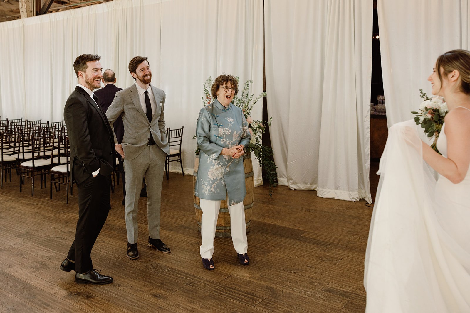 bride walks up to family members who look at her in awe
