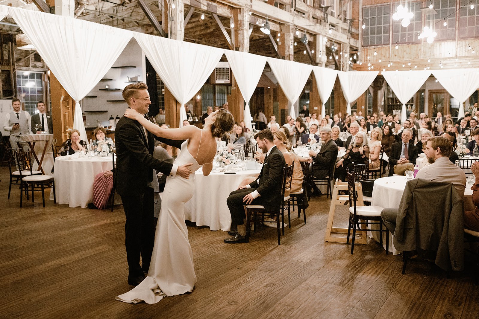 bride and groom dance in front of their guests at sodo park
