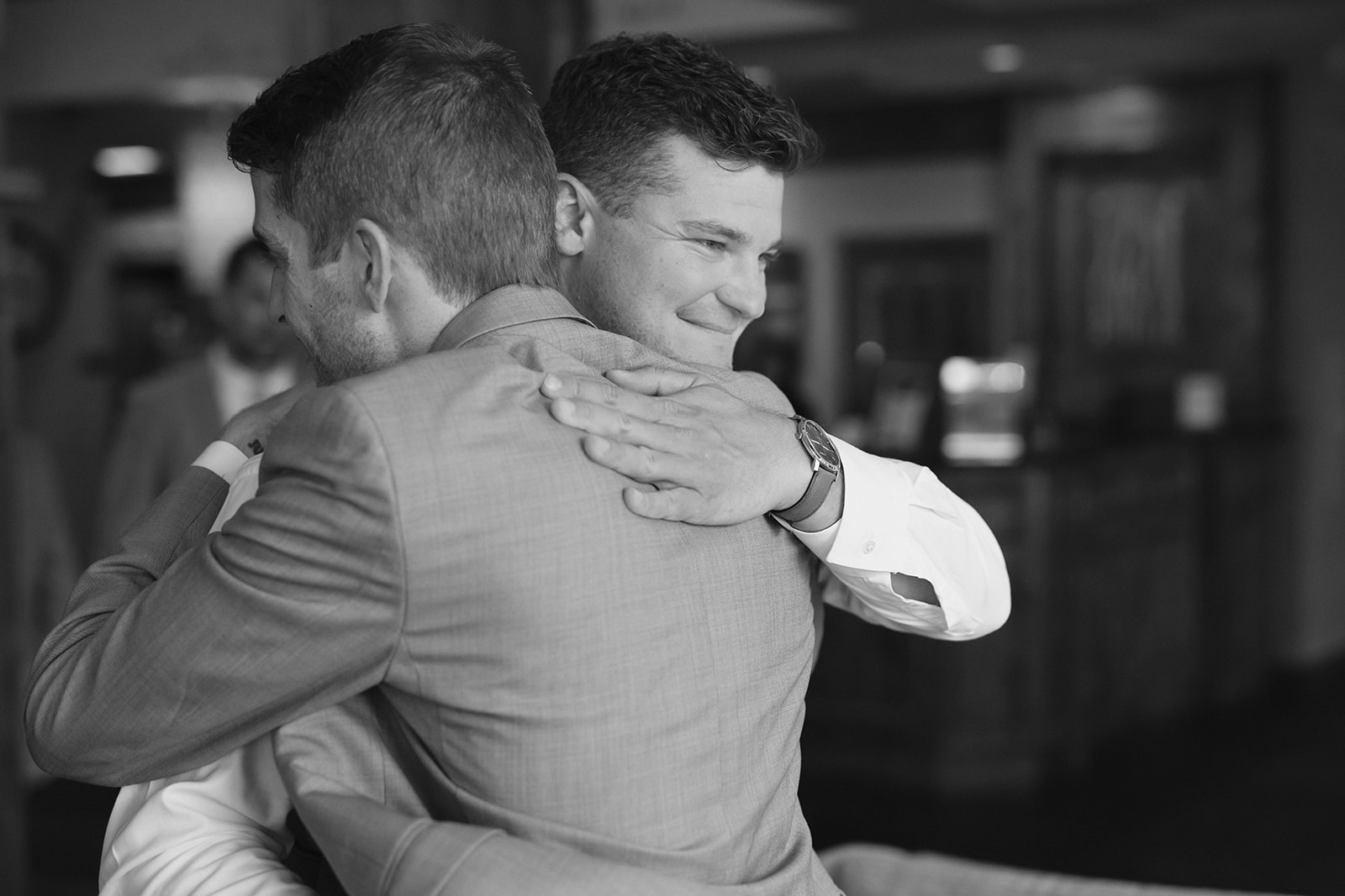 groom and man hug each other during getting ready photos