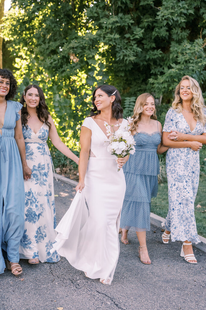 bride walks with her bridesmaids in blue
